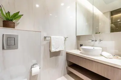 a white bathroom with a sink and a mirror at GuestReady - Studio | Canal View & Burj Khalifa in Dubai