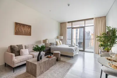 a white living room with a bed and a couch at GuestReady - Studio | Canal View & Burj Khalifa in Dubai