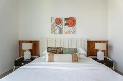 a bedroom with a white bed with two lamps at GuestReady - Luxury with a Private Pool | 2 BHK in Dubai