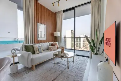 a living room with a couch and a large window at GuestReady - Luxury with a Private Pool | 2 BHK in Dubai