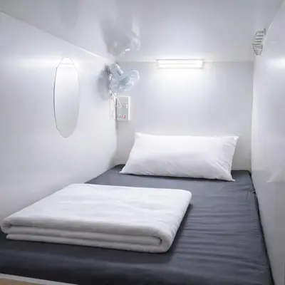 a small room with two beds and a fan at Dubai Beach Living JBR Hostel in Dubai