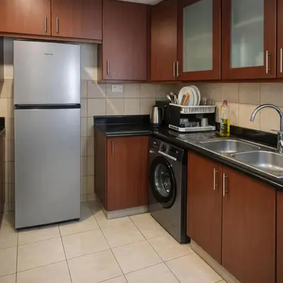 a kitchen with a refrigerator and a washing machine at Dubai Beach Living JBR Hostel in Dubai