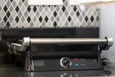 a toaster oven with a silver handle on top at Cozy 2BR Aykon City Near Downtown - Pool and Gym in Dubai