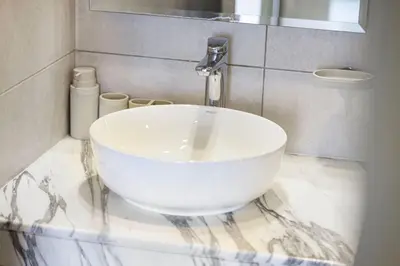 a bathroom with a white sink on a marble counter at Cozy 2BR Aykon City Near Downtown - Pool and Gym in Dubai