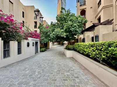 an empty street in a city with pink flowers at Downtown close to Dubai mall in Dubai