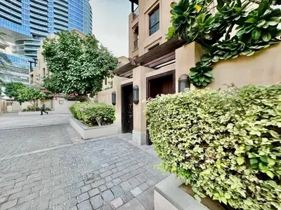 a brick walkway next to a building with bushes at Downtown close to Dubai mall in Dubai