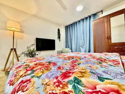 a bedroom with a large bed with a floral bedspread at Al Khaleej Apartments Karama in Dubai