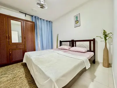 a bedroom with a bed with two pink pillows at Al Khaleej Apartments Karama in Dubai