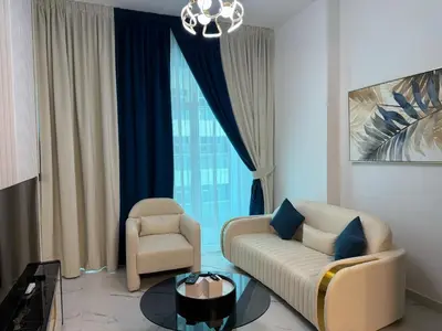 a living room with a couch and a chair at Studio and One bedroom in Danube Opalz by The S Holiday Homes in Dubai