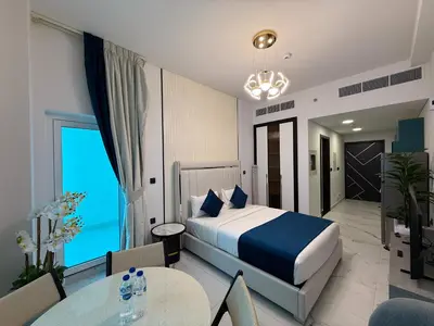 a hotel room with a bed and a table and chairs at Studio and One bedroom in Danube Opalz by The S Holiday Homes in Dubai