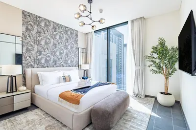 a bedroom with a large bed and a large window at Sobha Crest Luxury Apartments in Dubai