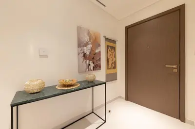 a hallway with a table with vases and a door at 1BR Sea View at Grand Bleu - Emaar Beachfront in Dubai