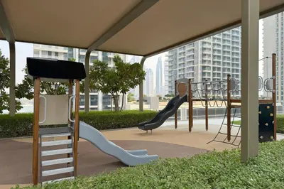 a play area with a slide and a playground at 1BR Sea View at Grand Bleu - Emaar Beachfront in Dubai