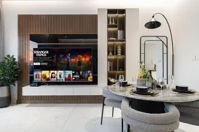 a dining room with a tv and a table with chairs at La Brisa Exclusive 3BHK at 1JBR Sea Palm Royal Atlantis Burj AlArab View with Private Beach and Pool By La Brisa Dubai in Dubai