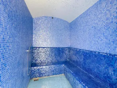 a blue tiled bathroom with a tub with a shower at Savis Homes - Zada Tower Luxury Escape - Close to Dubai Mall & Burj Khalifa in Dubai