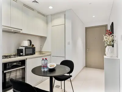 a kitchen with a small table and chairs in a room at Savis Homes - Zada Tower Luxury Escape - Close to Dubai Mall & Burj Khalifa in Dubai