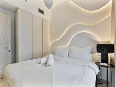 a white bedroom with a large white bed with white pillows at Savis Homes - Zada Tower Luxury Escape - Close to Dubai Mall & Burj Khalifa in Dubai