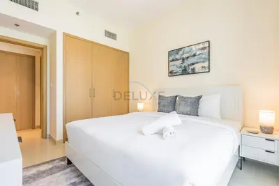 a bedroom with a large white bed and a desk at Partial Creek Harbour Views, Close to the Creek Harbour Marine Station and Harbour Promenade, Just Minutes from a Park, Harbour Views Tower 2, Dubai Creek Harbour by Deluxe Holiday Homes in Dubai