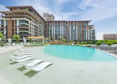 a swimming pool with lounge chairs and a large building at Elegant 1 Bedroom with Balcony in City Walk in Dubai