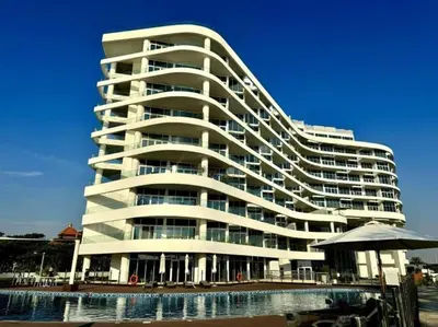 a large white building with a pool in front of it at VayK - Luxurious 2BR on the Palm with Private Beach Access in Dubai