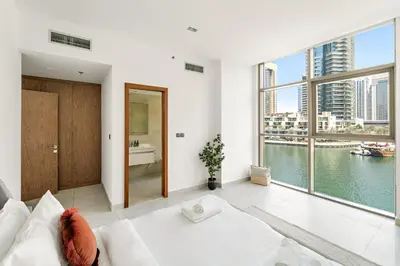 a white living room with a view of the water at Vayk - Bright and Spacious 2BR with Panoramic Marina Views in Dubai