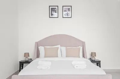 a bedroom with a white bed with two night stands at Vayk - Bright and Spacious 2BR with Panoramic Marina Views in Dubai