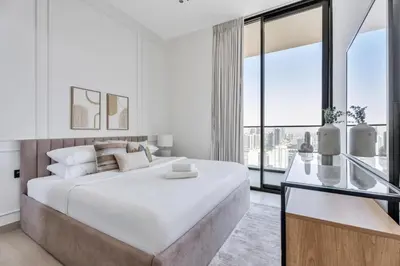 a white bedroom with a large bed and large windows at GuestReady - High floor Luxury with a Private Pool in Dubai