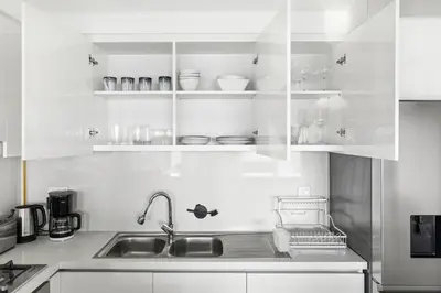 a kitchen with white cabinets and a sink at Luxury 2BR Walk-In Closet Full Burj Khalifa View in Dubai