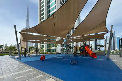 a playground with awning and play equipment in a city at Luxury 2BR Walk-In Closet Full Burj Khalifa View in Dubai