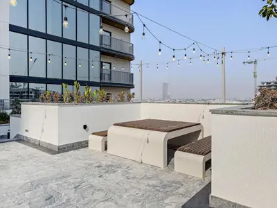 a building with two beds on a patio at Inspiring 1BR Apartment at Sobha Hartland in Dubai