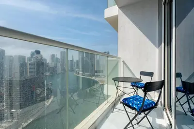 a balcony with two chairs and a table on a building at GuestReady - Damac Prive | 1BR Canal View in Dubai