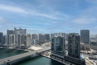 a city with a bridge over a river and buildings at GuestReady - Damac Prive | 1BR Canal View in Dubai