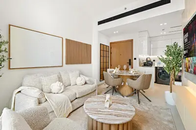 a living room with a couch and a table at Cozy 1 Bedroom in JVC with Stunning City Views in Dubai