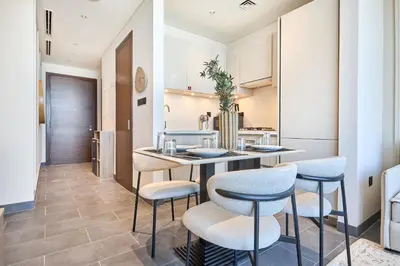 a kitchen with a table and chairs in a room at STAY BY LATINEM Luxury 1BR Holiday Home CB 0810 Near Burj Khalifa in Dubai