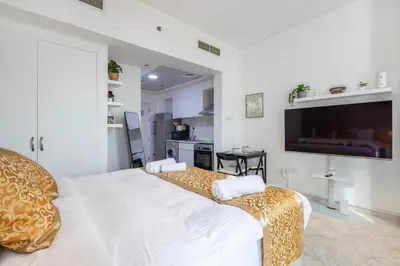 a bedroom with a bed and a flat screen tv at Park Central, Business Bay - Studio Apartment - Allsopp & Allsopp in Dubai