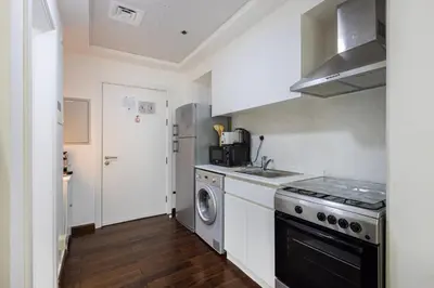 a kitchen with a stove and a sink and a dishwasher at Park Central, Business Bay - Studio Apartment - Allsopp & Allsopp in Dubai
