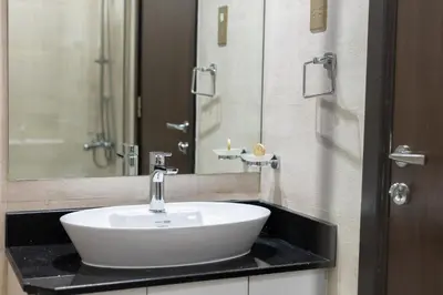 a bathroom with a white sink and a mirror at 1BR Poolside Serenity in JVT in Dubai