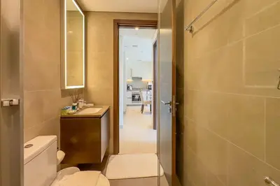 a bathroom with a toilet and a sink and a mirror at 1 Bedroom Apt in Sobha Creek Vistas Tower B by Luxaura in Dubai