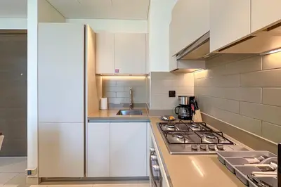 a kitchen with white cabinets and a stove top oven at 1 Bedroom Apt in Sobha Creek Vistas Tower B by Luxaura in Dubai