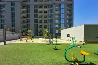 a playground with play equipment on a grass field at 1 Bedroom Apt in Sobha Creek Vistas Tower B by Luxaura in Dubai