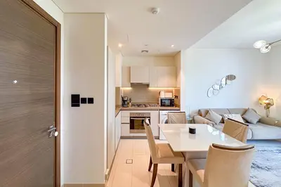 a kitchen and living room with a table and chairs at 1 Bedroom Apt in Sobha Creek Vistas Tower B by Luxaura in Dubai
