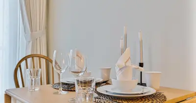 a table with plates and glasses on a table at Luxury Studio on Palm Jumeirah Beach Access in Dubai