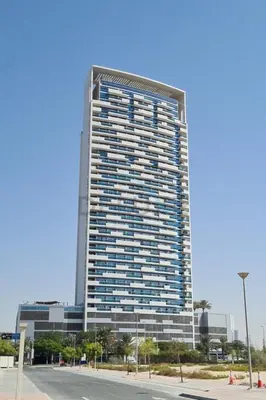 a tall building with a lot of windows at High-Floor Studio, Walking Distance to the Park and 15-Min Drive to Miracle Garden, Al Jawhara Tower, Jumeirah Village Triangle by Deluxe Holiday Homes in Dubai