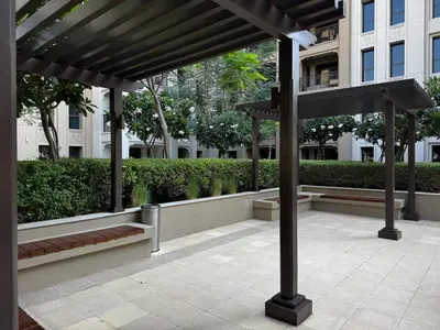 a wooden pergola with benches and a building at Luxury 1BR in Madinat Jumeirah Living in Dubai