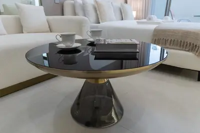 a glass coffee table in a living room with a couch at Elegant Studio Escape in JVC - by Czechin in Dubai