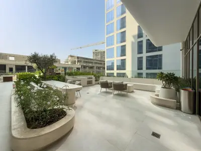 a balcony of a building with tables and chairs at Elegant Studio Escape in JVC - by Czechin in Dubai