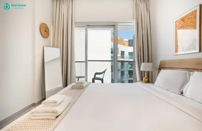 a bedroom with a large bed with towels on it at Blue Breeze Modern 2BR Apartment Near Downtown in Dubai
