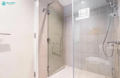 a shower with a glass door in a bathroom at Blue Breeze Modern 2BR Apartment Near Downtown in Dubai