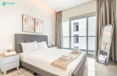 a bedroom with a bed and a large window at Blue Breeze Modern 2BR Apartment Near Downtown in Dubai