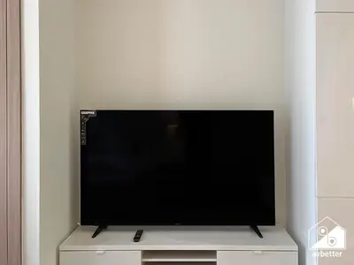 a flat screen tv sitting on top of a tv stand at Premium Riviera Studio King Bed, Pool & Gym in Dubai